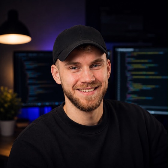 Conrad Caffier an seinem Schreibtisch, im Hintergrund Monitore mit Code